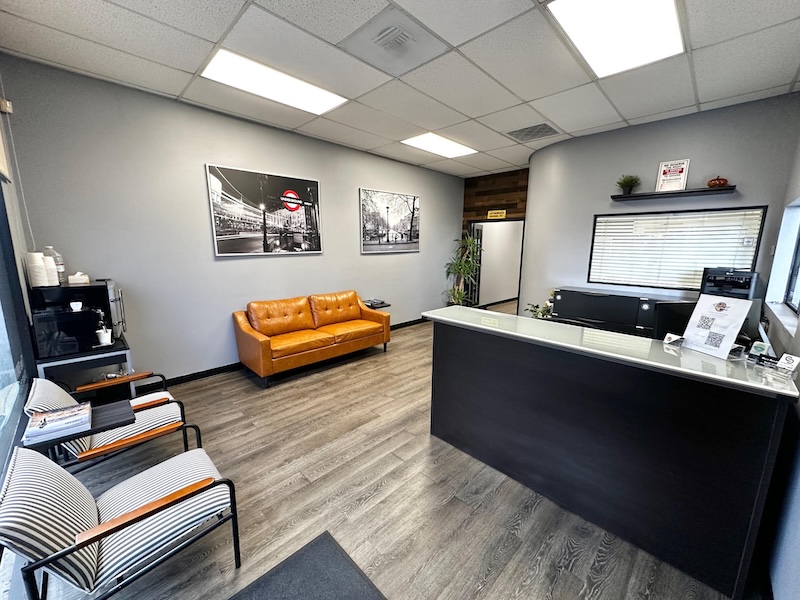 Waiting room with reception desk, comfortable chairs, coffee area.
